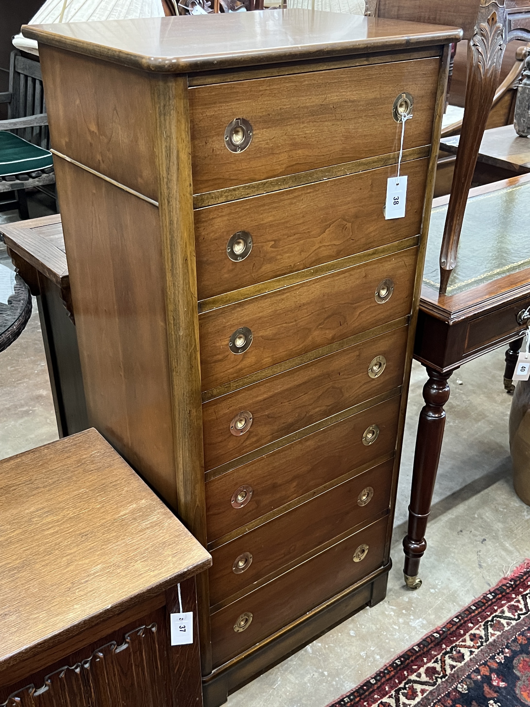 A military style seven drawer tall chest, with recessed brass handles width 57cm, depth 43cm, height 126cm.